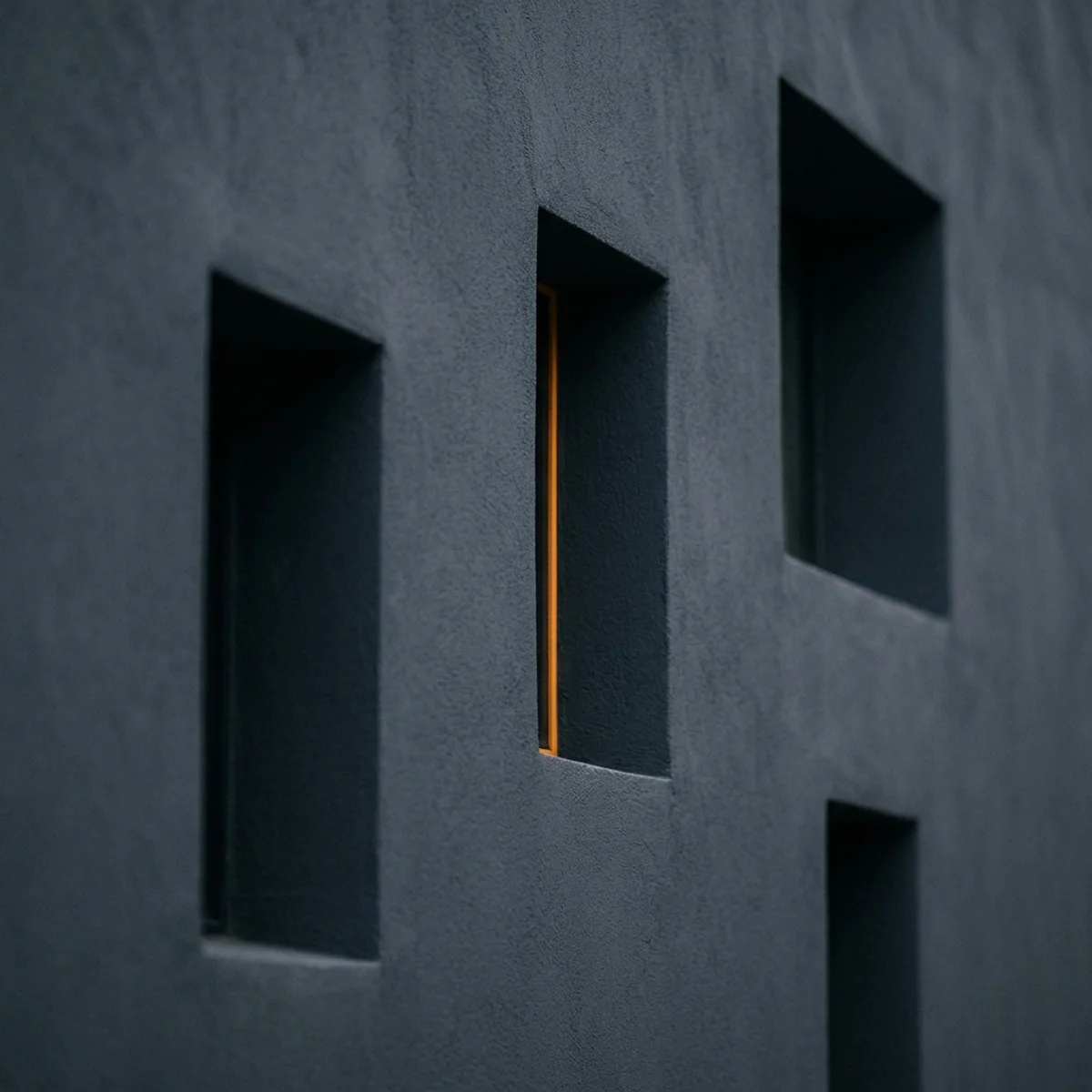 Abstract editorial grid of four recessed rectangular openings with one amber reveal line